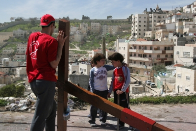 Counties evangelist Clive Cornish climbs the Mount of Olives outside Jerusalem with his cross. Two local children come and speak during a project called From Jerusalem to Rome in the Footsteps of the Apostle Paul.