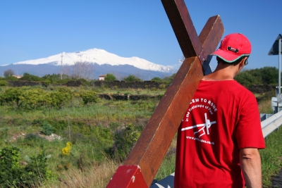 Counties evangelist Clive Cornish carries his cross past the volcano Mount Etna, Sicily – photographed during a project called From Jerusalem to Rome in the Footsteps of the Apostle Paul. Counties evangelist Clive Cornish carries his cross past the volcano Mount Etna, Sicily - photographed during a project called From Jerusalem to Rome in the Footsteps of the Apostle Paul.
