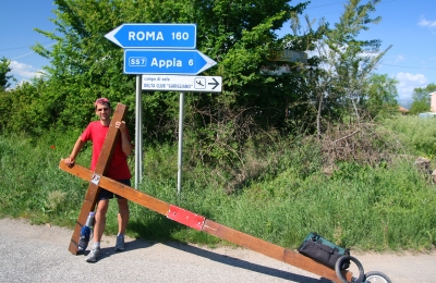 Counties evangelist Clive Cornish stops with his cross by a sign to Rome and the Via Appia – photographed during a project called From Jerusalem to Rome in the Footsteps of the Apostle Paul. Counties evangelist Clive Cornish stops with his cross by a sign to Rome and the Via Appia - photographed during a project called From Jerusalem to Rome in the Footsteps of the Apostle Paul.