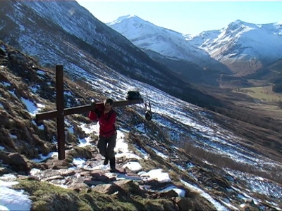 Counties evangelist Clive Cornish ascends Ben Nevis from Glen Nevis carrying a wooden cross, the steep roack path means Clive has to shoulder the heavy cross