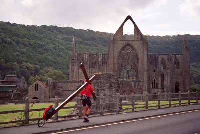 Counties evangelist Clive Cornish walks with his cross towards the ruins of Tintern Abbey in the Wye Valley